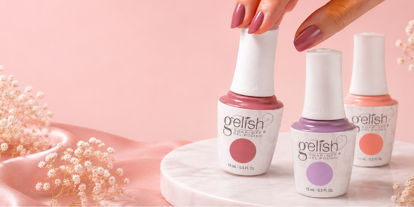 Gelish nail polish bottles on a pink background with a hand holding one bottle.